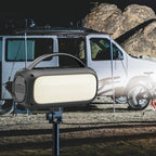 Portable light on a stand with a vehicle and rocky landscape in the background