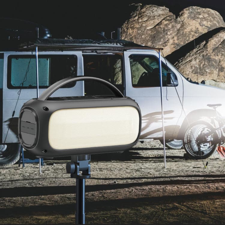 Portable light on a stand with a vehicle and rocky landscape in the background