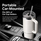 A white insulated travel tumbler with a handle and clear straw, shown mounted in a car cup holder with promotional text on the left.