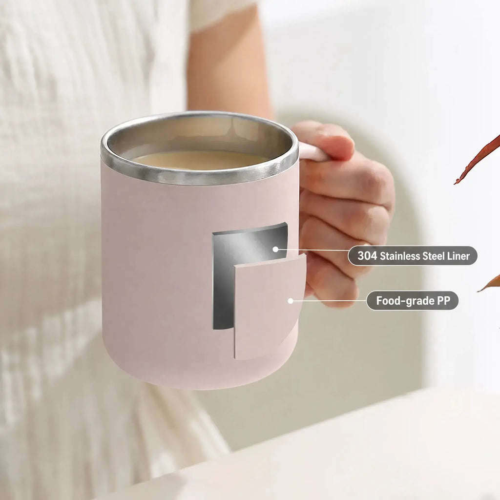 A person holds a light pink insulated mug with a stainless steel liner and a sliding cover. Text callouts on the image identify the 304 stainless steel liner and food-grade PP material.