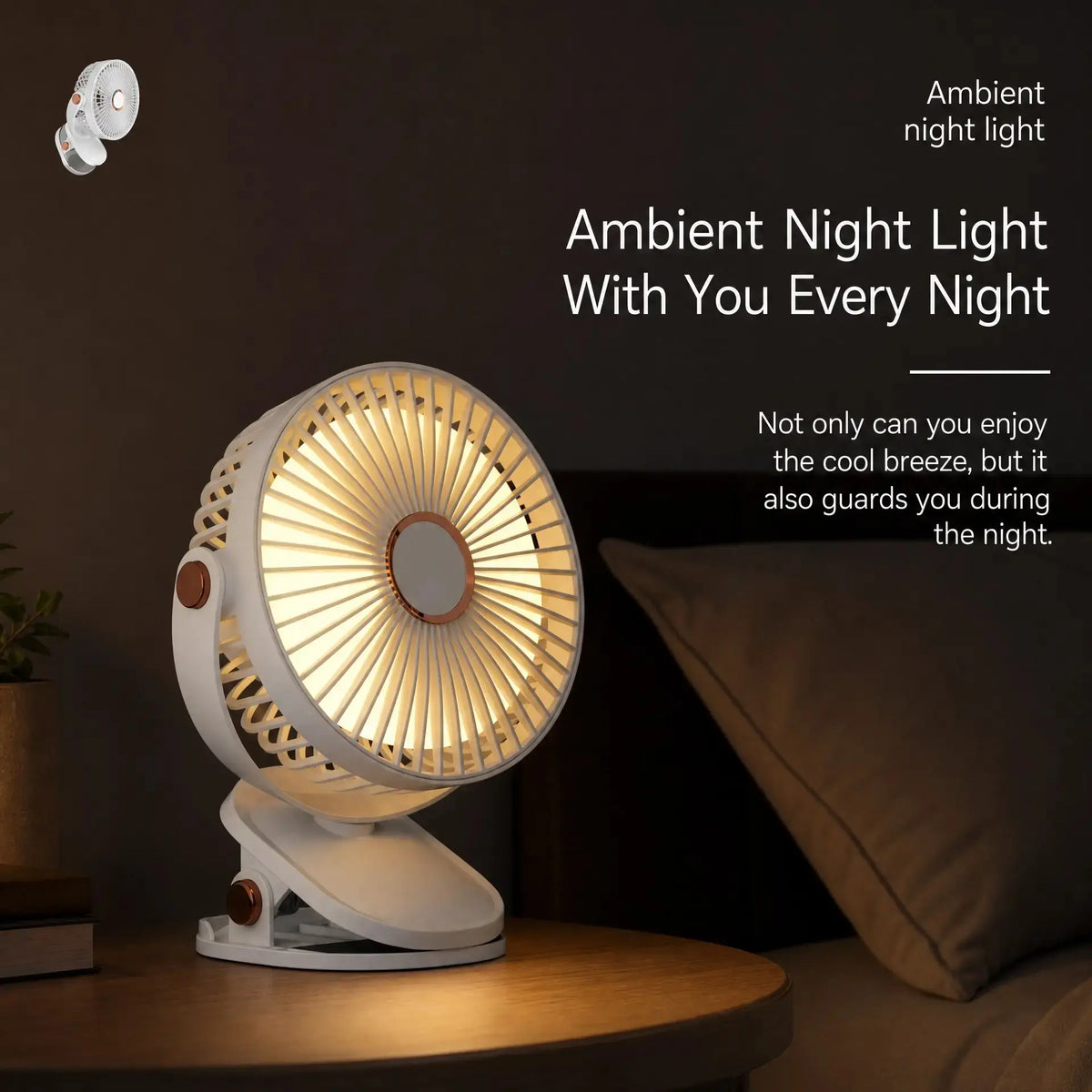 A small white fan with warm amber LED light glowing from the front, shown on a wooden table in a dim bedroom setting next to a pillow. White text on the right reads 'Ambient night light With You Every Night' with additional descriptive copy.
